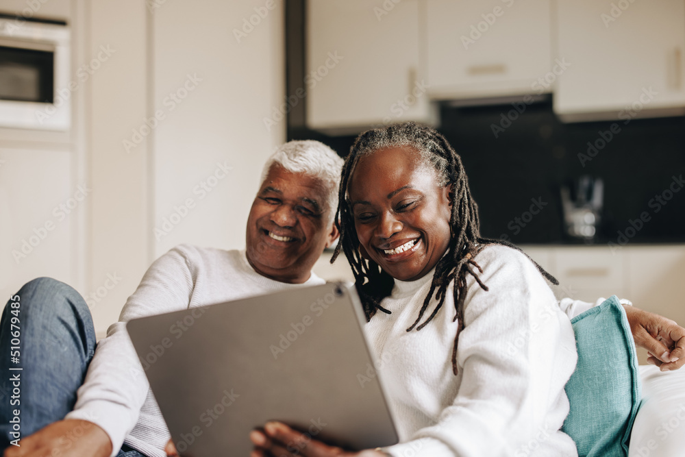无忧无虑的老年夫妇在数字平板电脑上进行视频通话