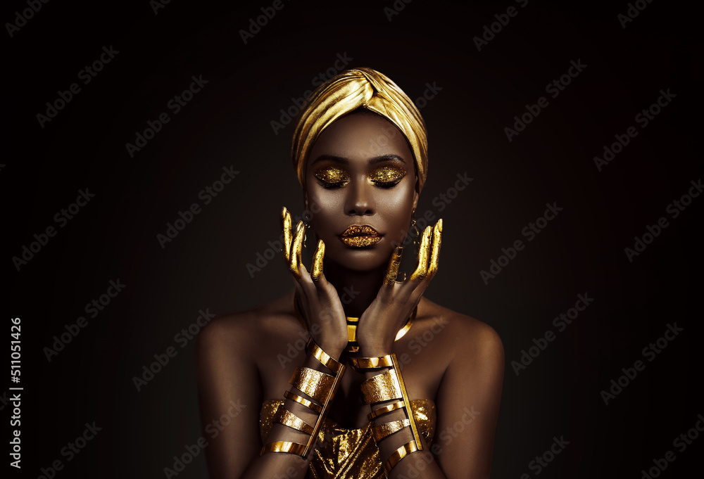 肖像特写美丽幻想非洲女人的脸，金色油漆。金色闪亮的黑色皮肤。时尚m