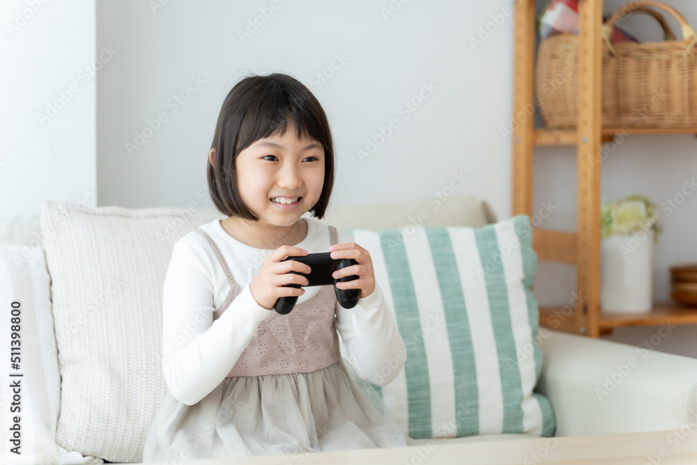 リビングでテレビゲームをプレイする女の子