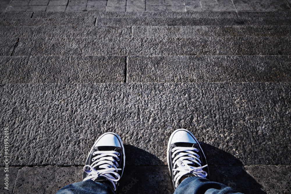 提升你的风格。一个人穿着运动鞋站在台阶上的POV镜头。