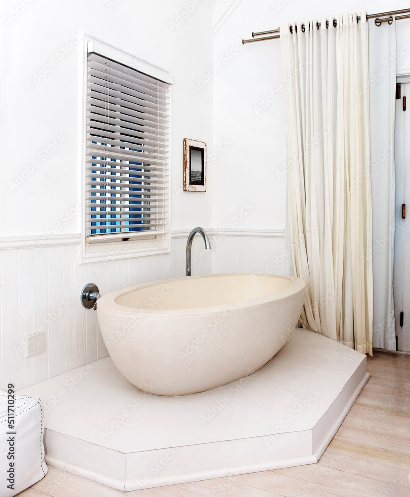 步入现代奢华。时尚浴室角落里有漂亮的白色浴缸。