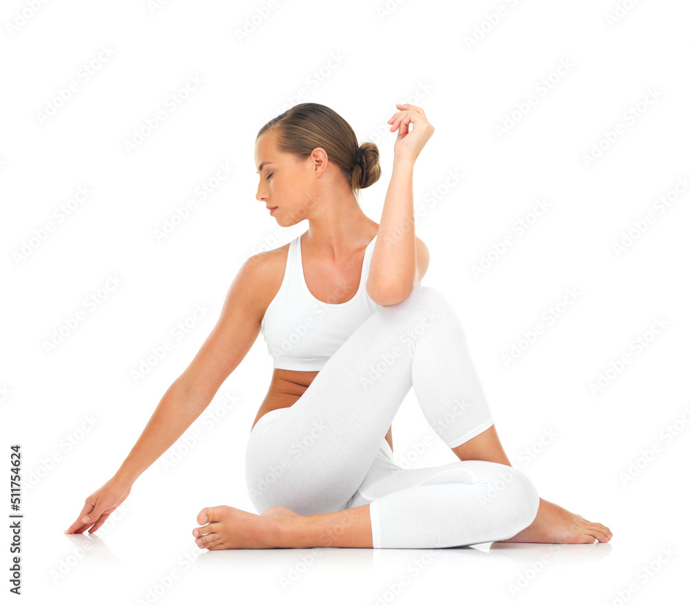 Limbering up for a workout. A sporty young woman stretching against a white background.