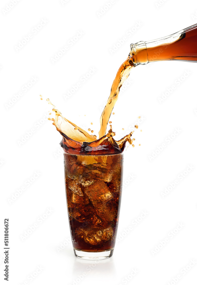 将可乐饮料倒入玻璃杯中，飞溅物在白色背景上隔离。