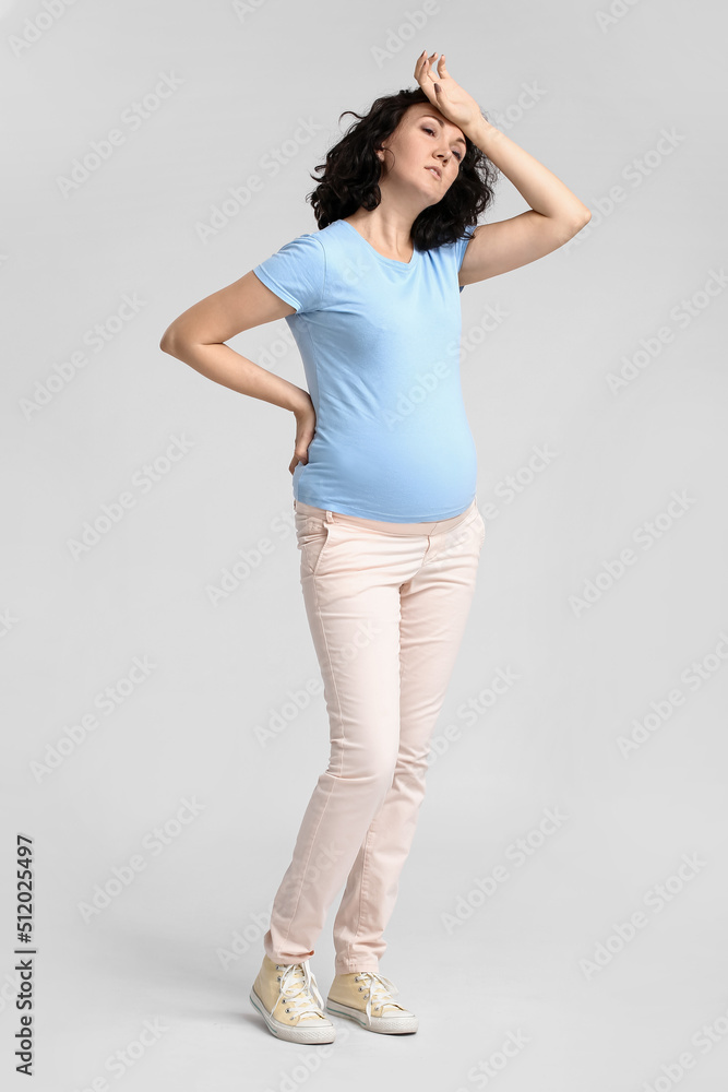 疲惫的年轻孕妇穿着浅底蓝色t恤