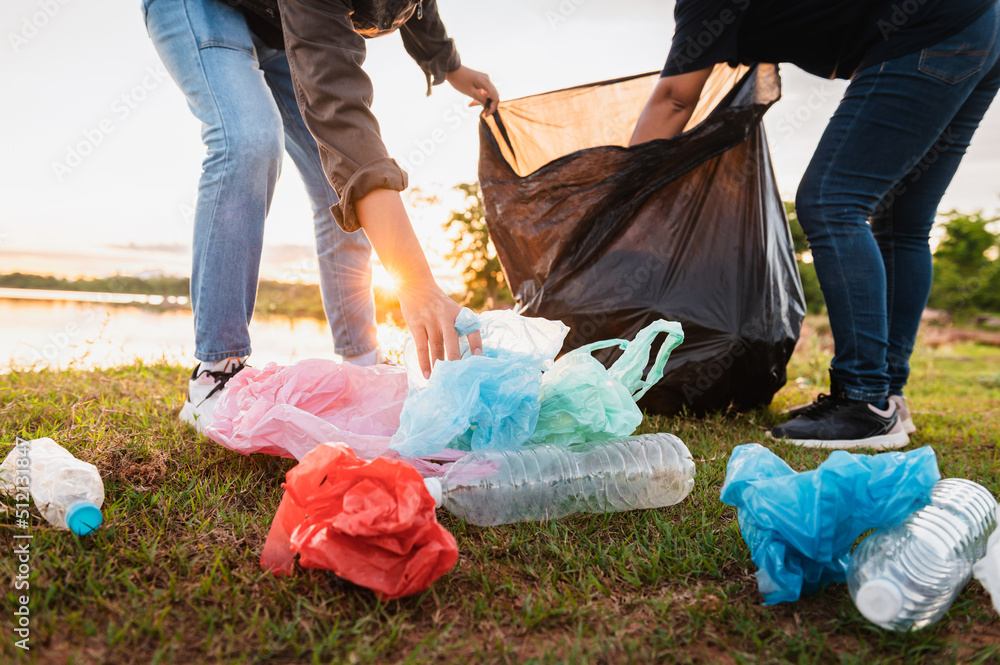 女子在公园用手捡垃圾塑料袋进行清洁