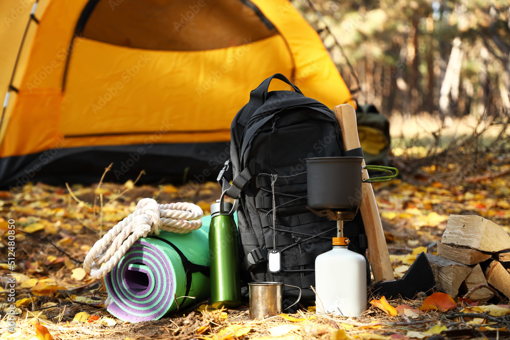 游客秋季森林生存装备和露营帐篷