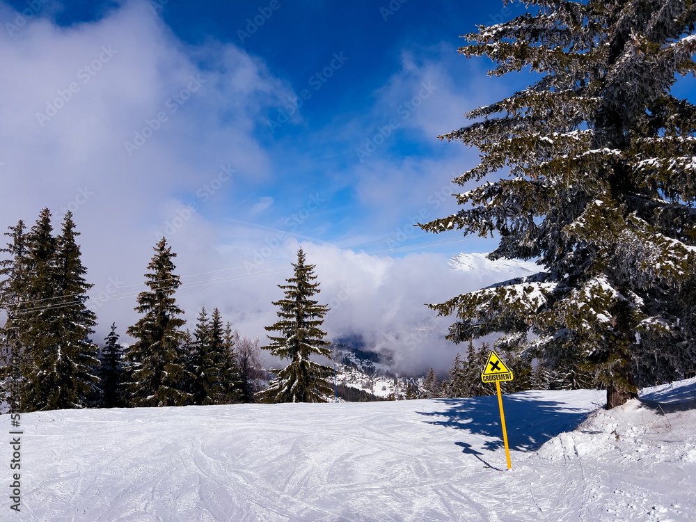 高空云层上有黄色交叉标志的滑雪道
