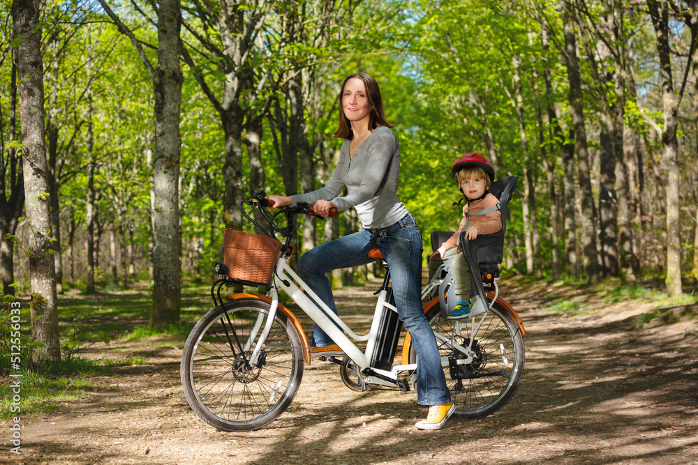 母亲带着孩子在公园里骑电动自行车
