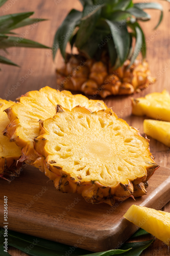 新鲜切好的菠萝放在深色木桌背景上的托盘上。