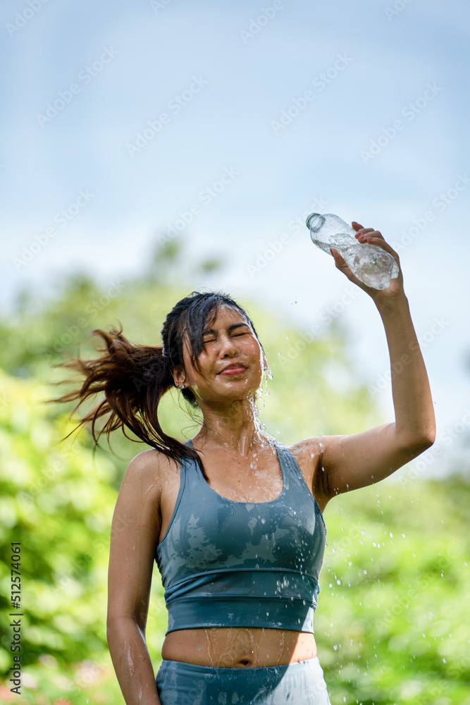 斯波尔夏季公园里，一位健身的女士在喝水，一位年轻口渴的女士在用瓶子喝水