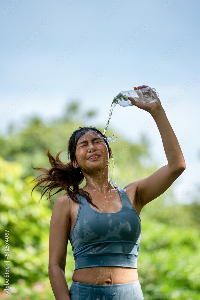 在斯波尔的夏季公园里，健身的女人在喝水，年轻口渴的女人在用瓶子喝水