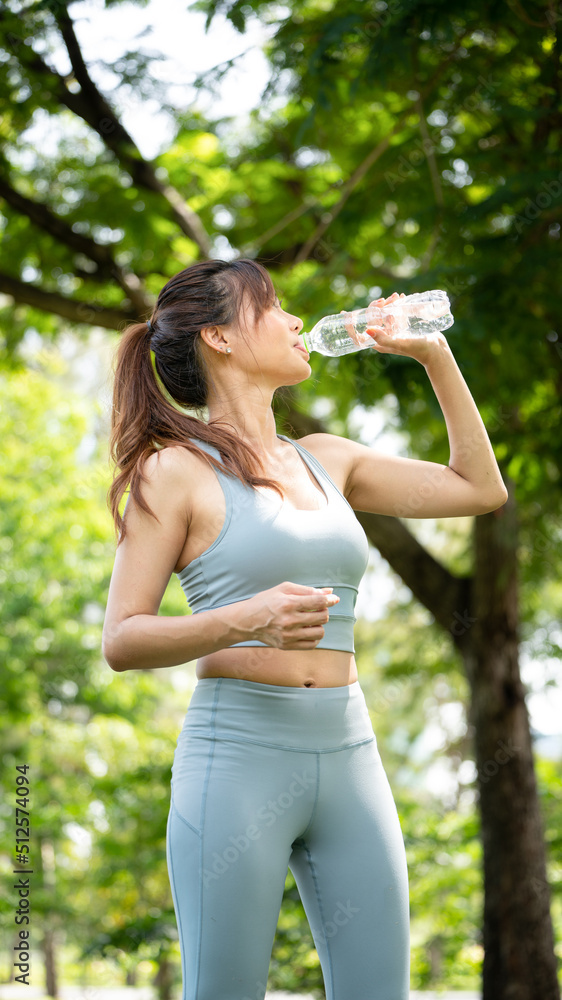 斯波尔避暑公园里，一个健身的女人在喝水，一个年轻口渴的女人在用瓶子喝水
