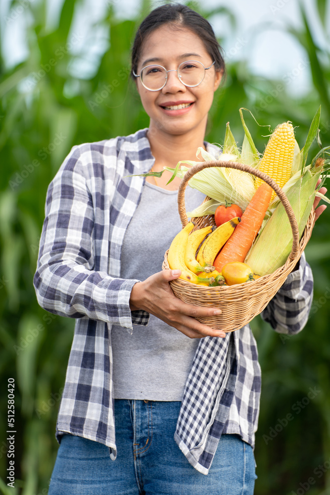 Beautiful young brunette Portrait Famer Woman hand holding Vegetables in the bamboo basket on green 
