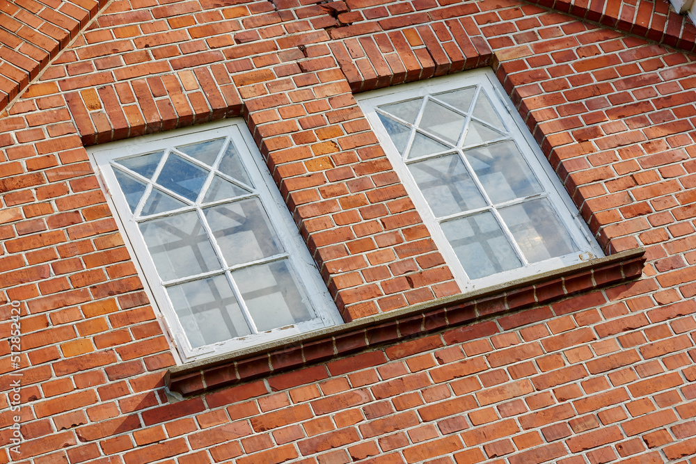 带两扇矩形窗户的旧石墙。带窗户的建筑矩形窗户的特写