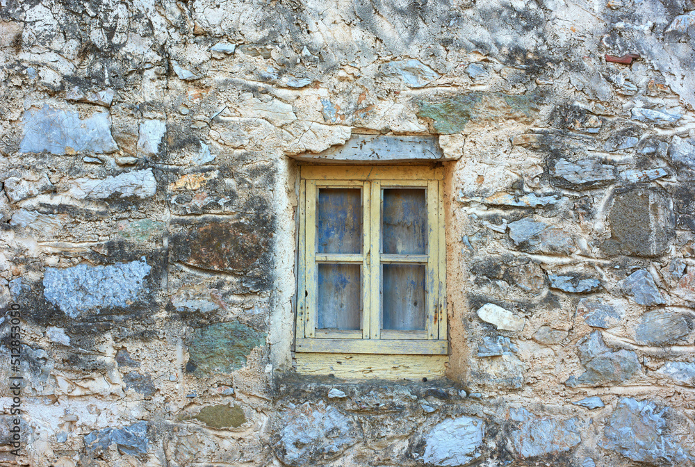 古老的粗糙石墙农舍或古房子上的木窗。复古、质朴、老式