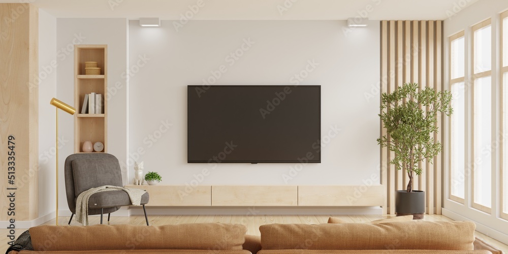 客厅橱柜上的白色壁挂电视，配有深棕色扶手椅和棕色沙发，最小设计