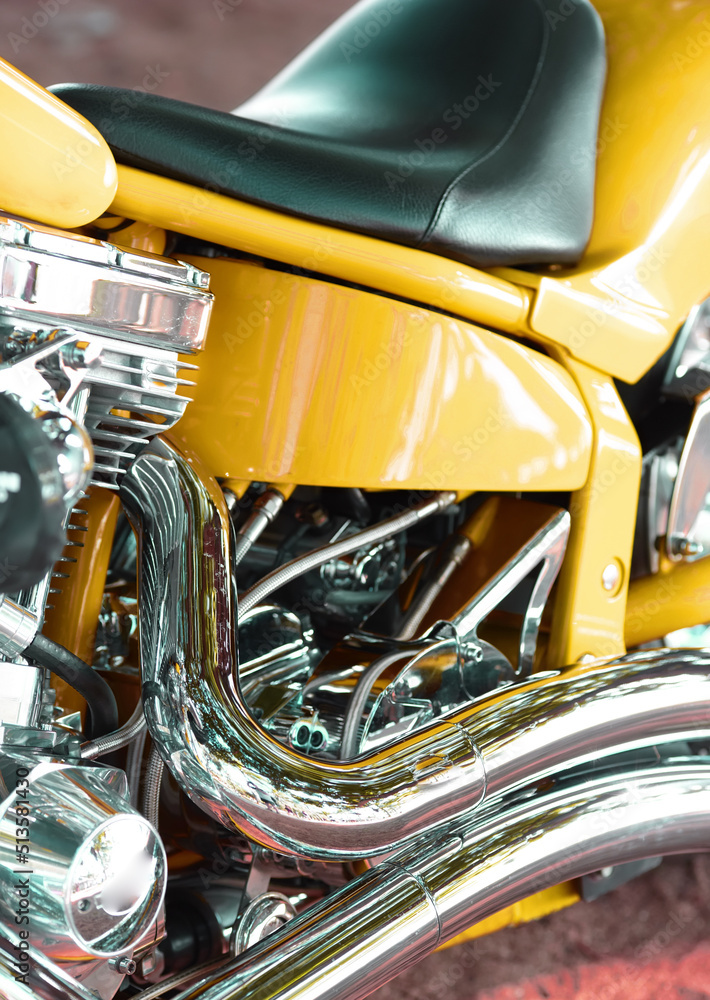 一辆定制设计的铬皮座椅摩托车的特写。一辆黄色豪华摩托车的细节