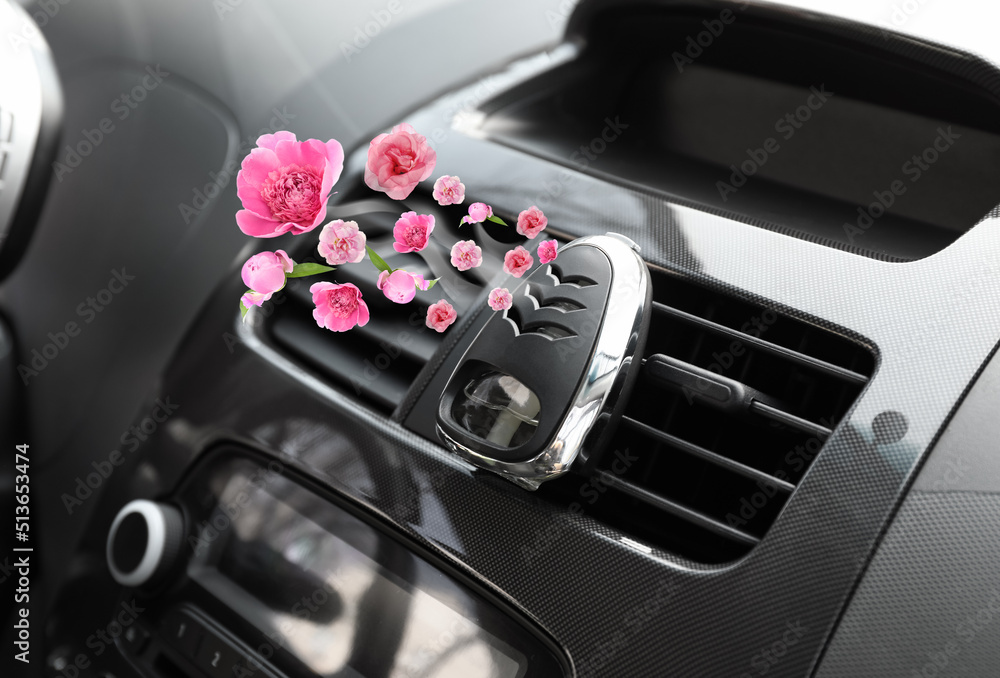 Aroma air freshener with flying fresh pink flowers in car salon