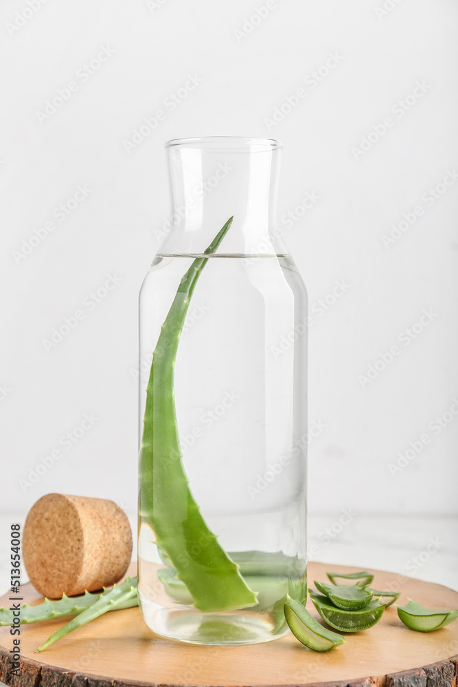 白底芦荟汁和叶子的玻璃瓶木板