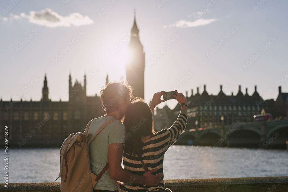 一对夫妇在探索伦敦时用智能手机拍摄大本钟的后视照片