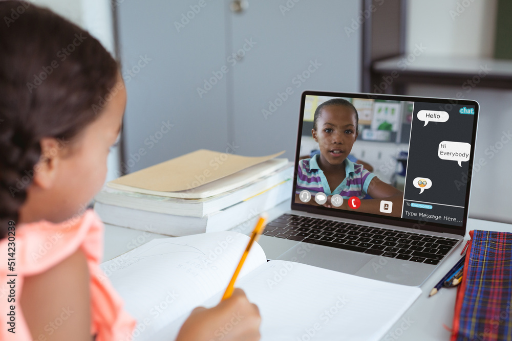 混血女孩看着笔记本电脑屏幕，非裔美国学生在网上演讲