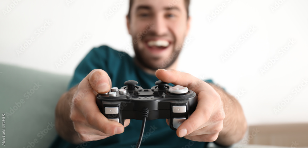 Young man playing video games at home, closeup