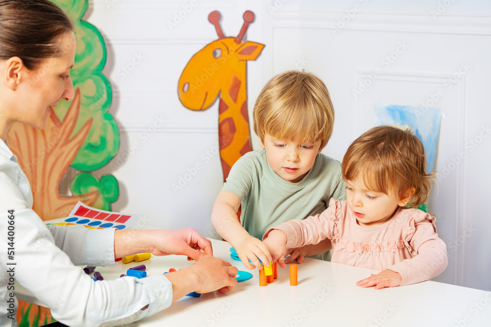 一个女人和两个幼儿园的小孩玩积木