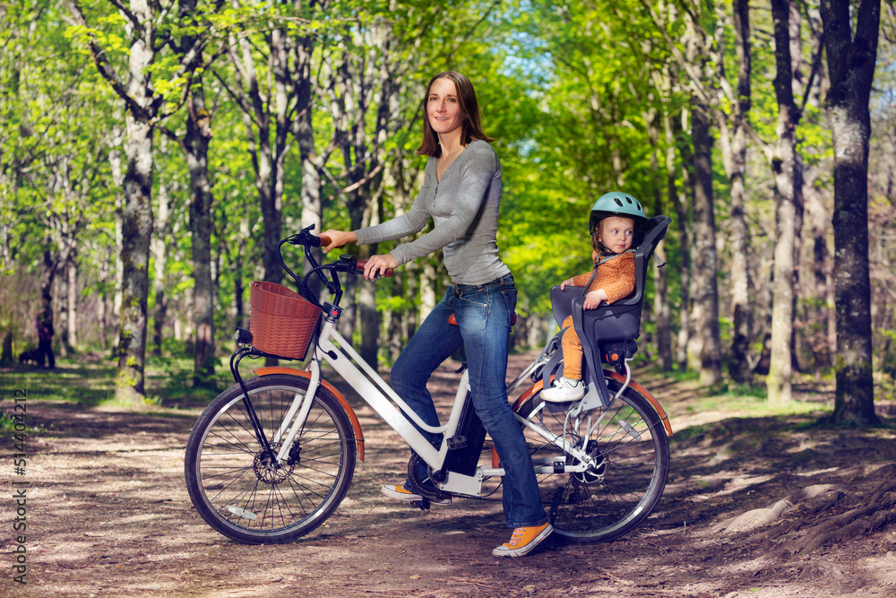 妇女和小女孩在公园巷子里骑城市电动自行车
