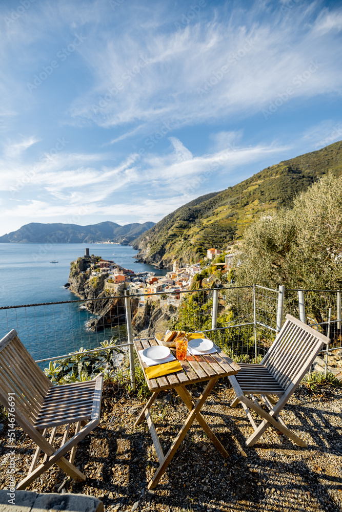 Served table for lunch on coast with beautiful view on Vernazza village in Italy. Traveling italian 
