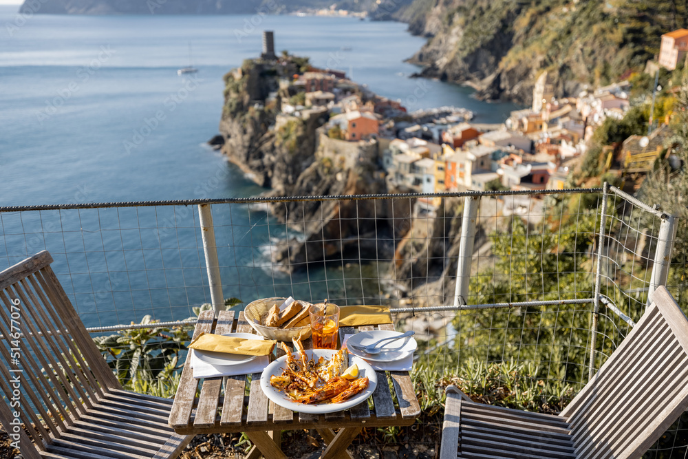 Served lunch table with seafood on coast at Vernazza village in Italy. Concept of mediterranean seaf