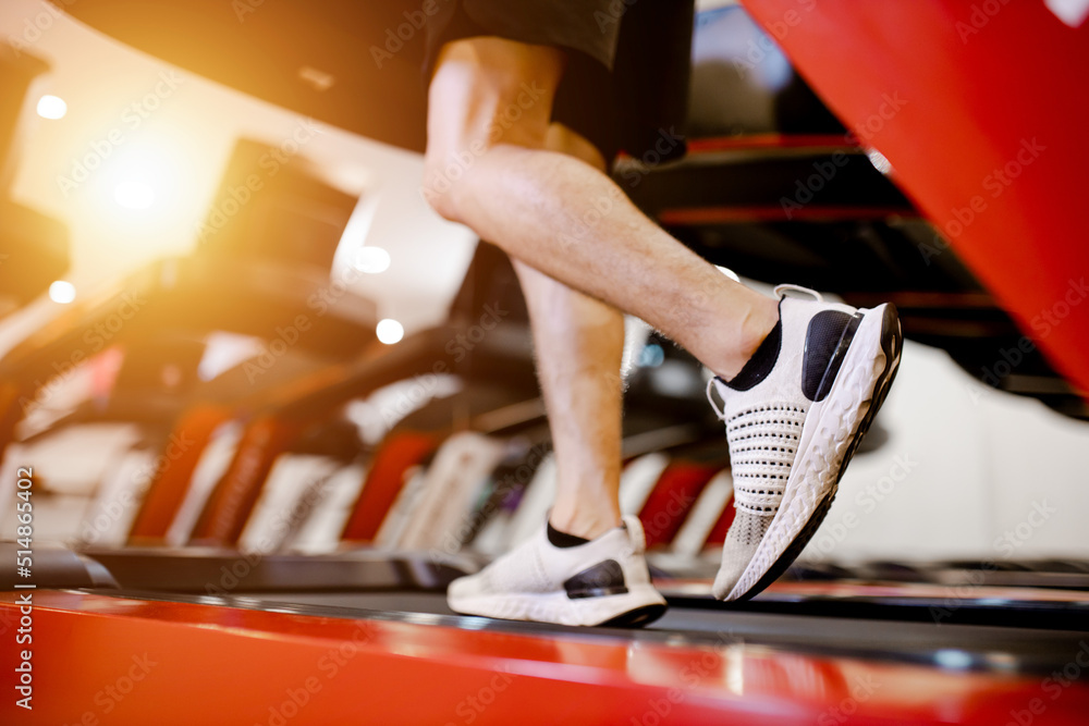 近距离观察运动鞋年轻人在健身馆的机器跑步机上跑步。e的概念