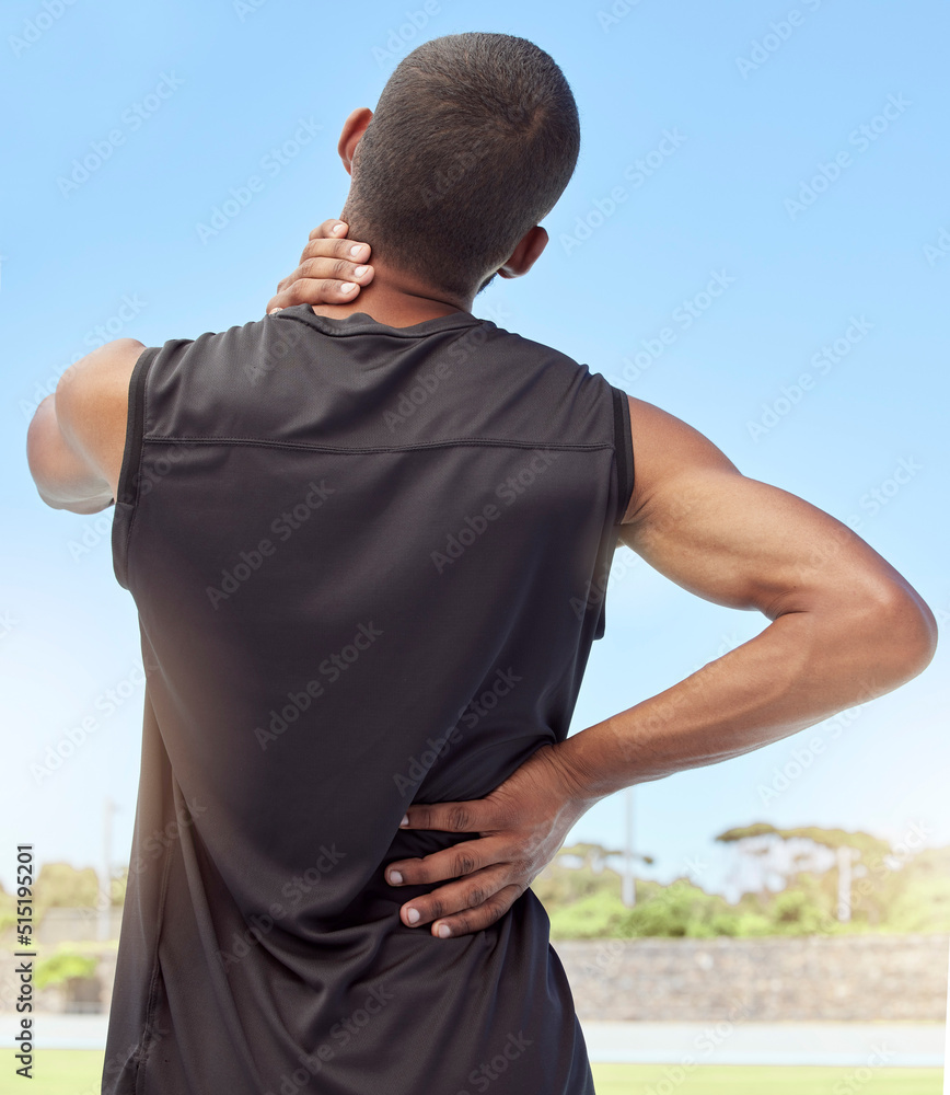 颈部疼痛运动员的后视图。一名不舒服的年轻运动员站着的特写后视图