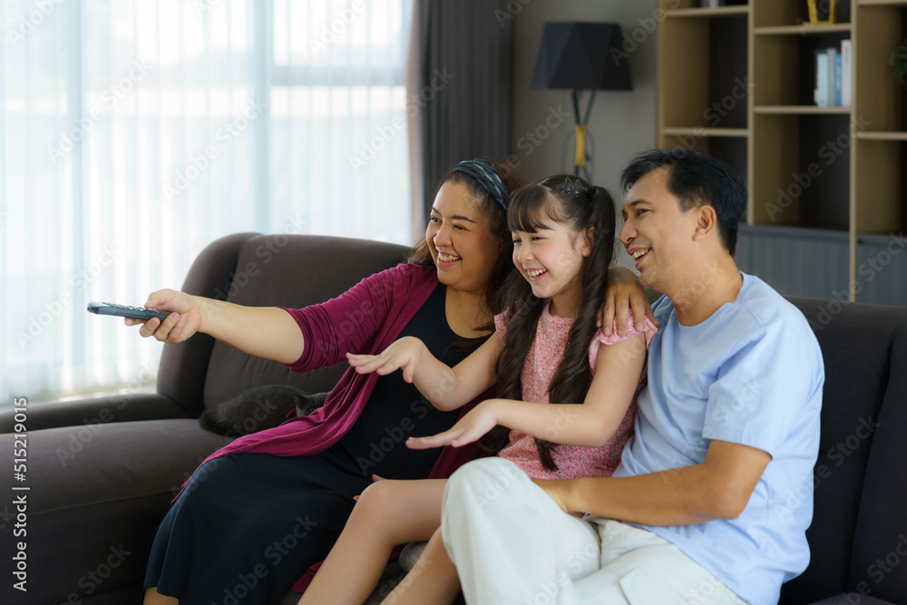 有爸爸、妈妈和女儿的快乐亚洲家庭享受周末活动，花更多时间在家里