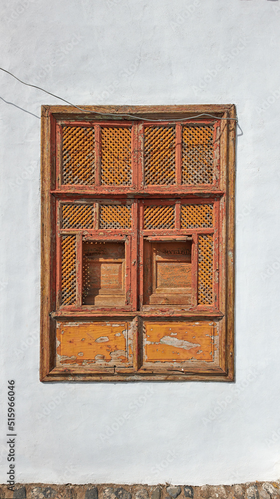 Architecture of an old grey wall with a rusted metal window outside. Exterior texture details of an 