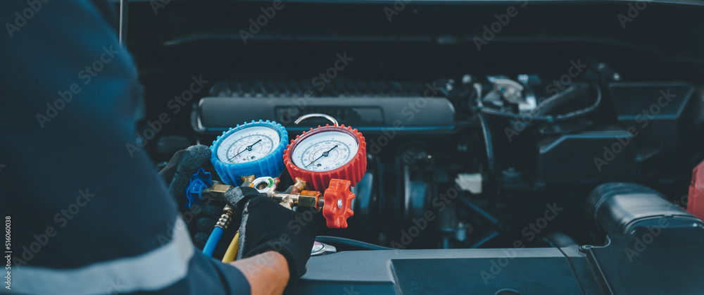 汽车修理工使用测量歧管仪表检查制冷剂和加注汽车的特写