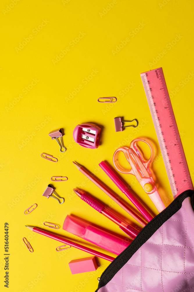 黄色表面有粉色学校物品和案例的作文垂直图像