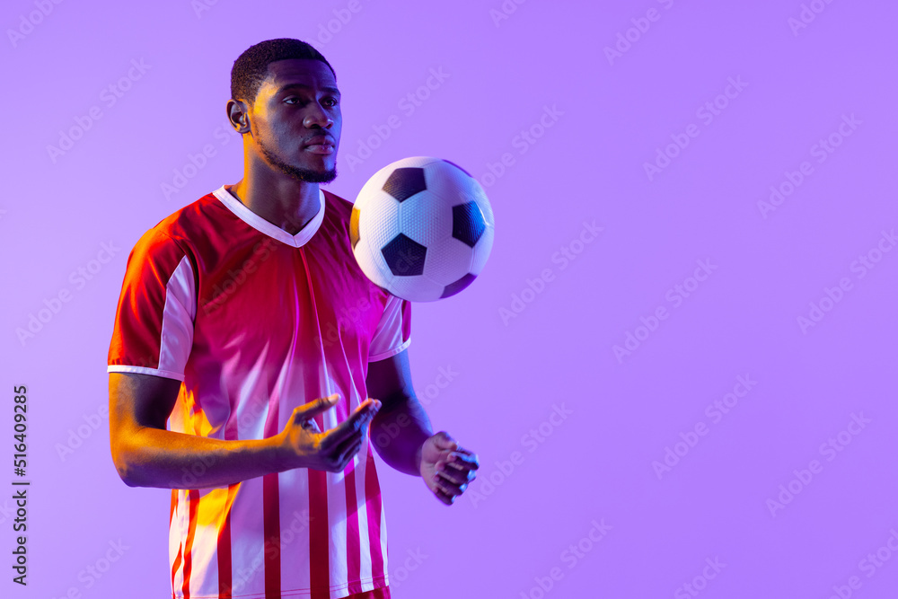 非洲裔美国男子足球运动员在霓虹灯下踢球