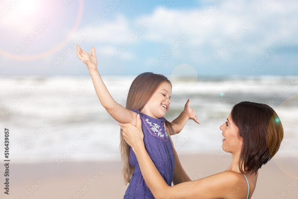 Mother with small child playing and having fun together on beach. Happy family outdoors. Mom and bab