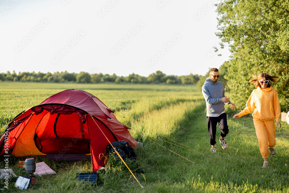 年轻夫妇在纳图带着帐篷旅行，玩得很开心，一起跑步，愉快地度过夏天