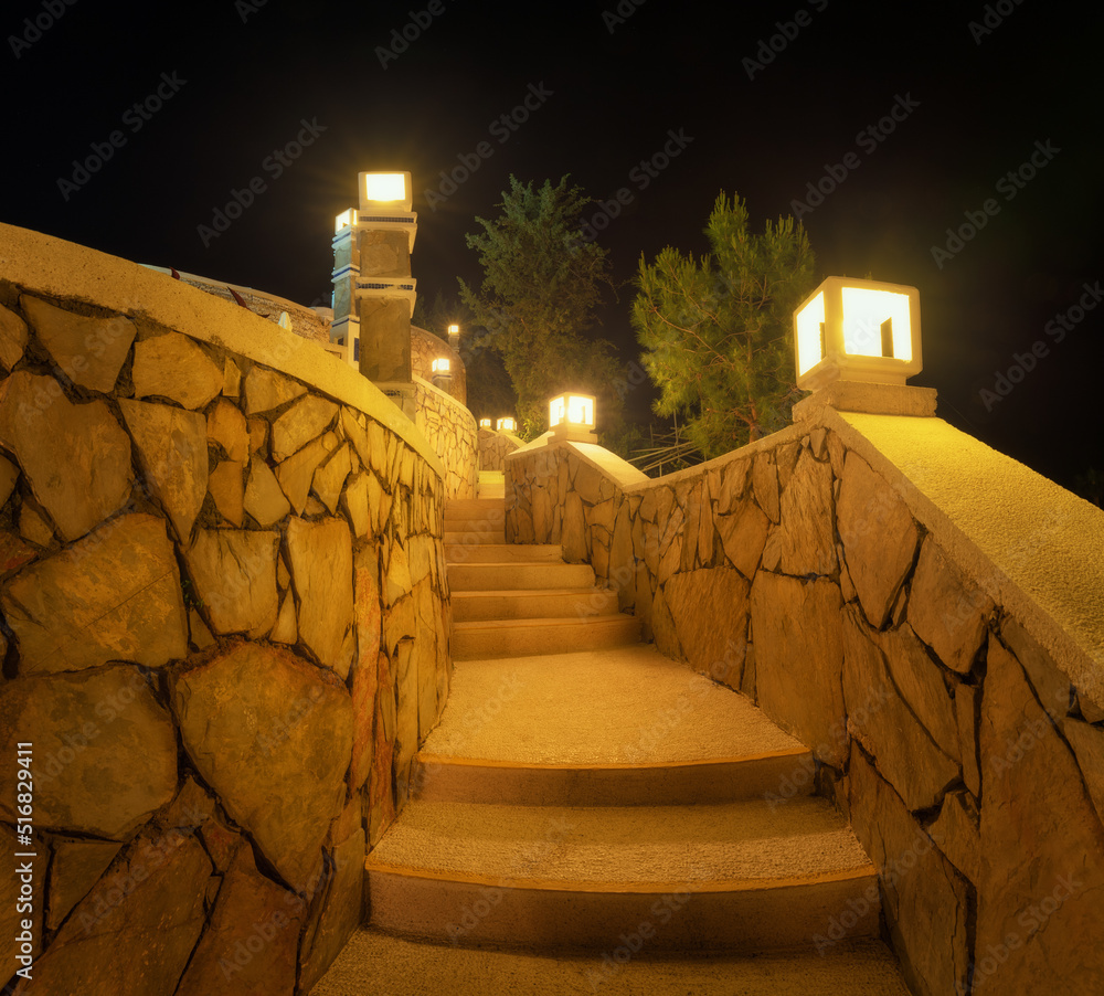 美丽的楼梯，夏天晚上有路灯。五颜六色的景观，石头台阶，发光