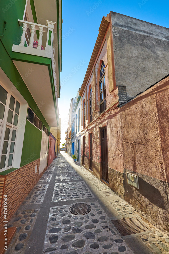 Empty cobbled street in a rural European tourist town. A quiet narrow alley way with colorful apartm