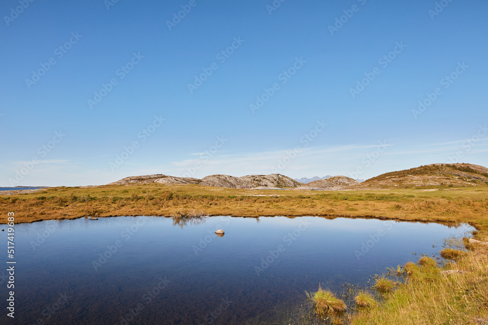 草地附近的湖泊景观，背靠群山的蓝色地平线。火星上的平静之水