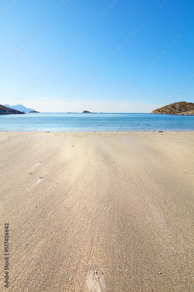 夏日里的一个放松海滩，是度假的理想之选。平静的蓝色海洋，米色的沙滩上有岛屿。