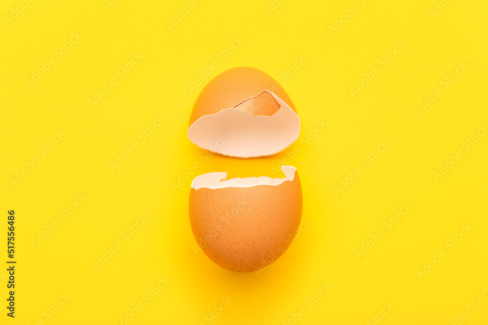 Cracked egg shell on yellow background