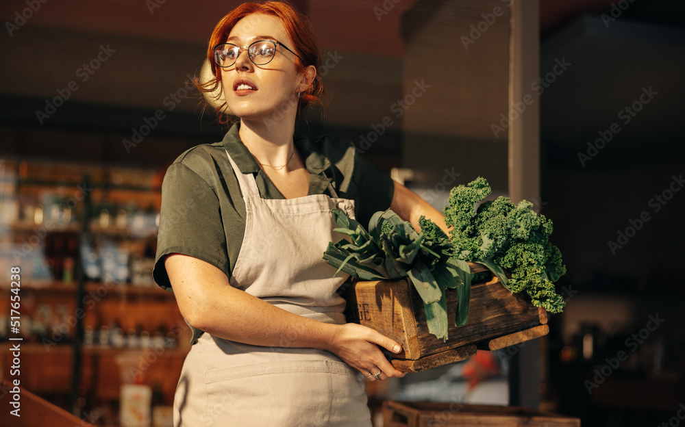 女店主拿着一盒新鲜有机蔬菜