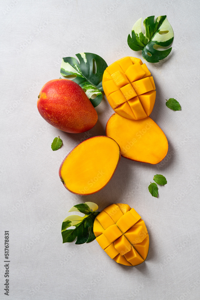 芒果背景设计理念。俯视图，灰色桌子上的新鲜芒果切块。