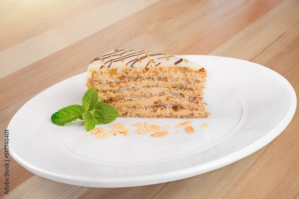 美味的甜蛋糕，白色陶瓷盘上装饰着新鲜的绿色薄荷叶。传统甜点。
