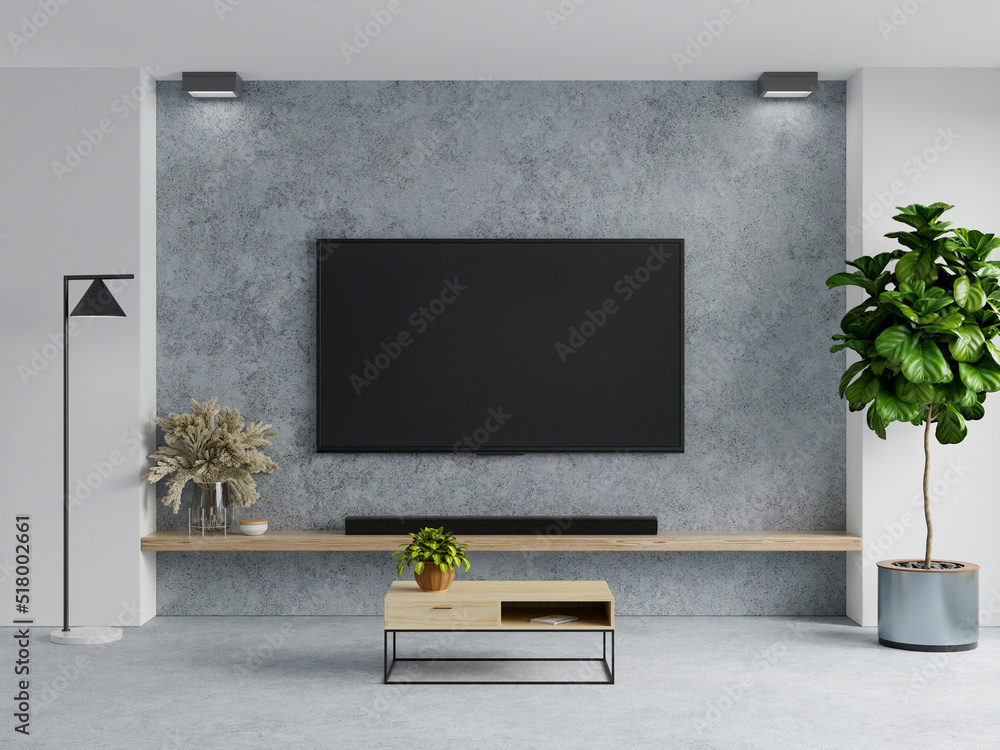 客厅内部混凝土背景的混凝土壁挂式电视。