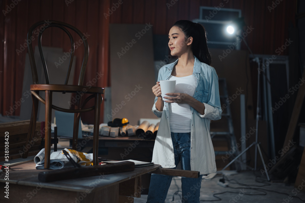 年轻的亚洲设计师家具女木匠在工作台上用卷尺测量椅子