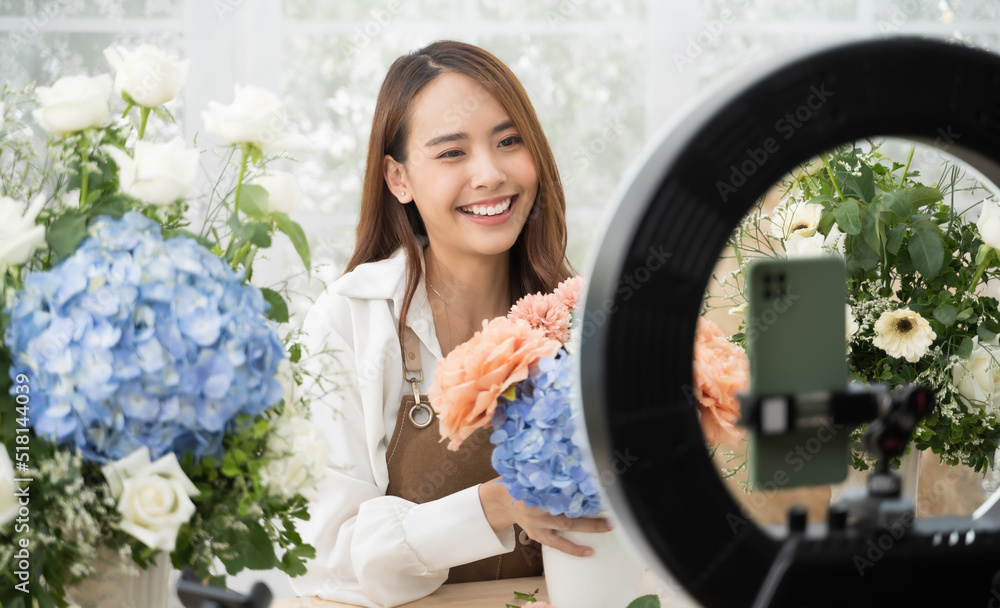 年轻的亚洲女性在家进行在线展示和直播，以出售她的送花服务